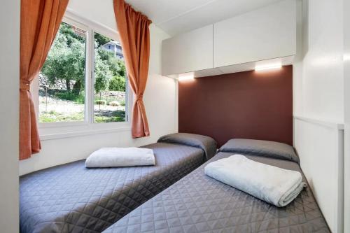 普雷多雷Camping Eurovil的一间卧室设有两张床和窗户。