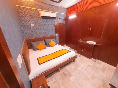 阿格拉幸运餐厅和旅馆的一间卧室配有带橙色和黄色枕头的床