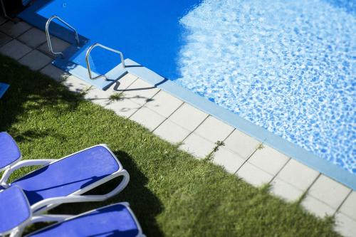 西兰德罗索能伯格旅馆的两把蓝色椅子坐在游泳池旁