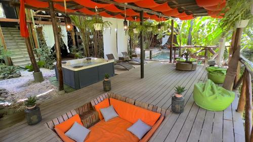 圣塔特蕾莎海滩卡奈玛清凉别墅酒店的户外甲板配有橙色沙发和浴缸