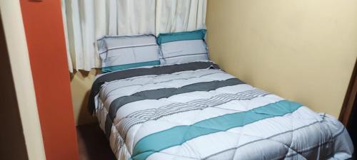 豪哈C&B APARTAMENTOS的一张带蓝色和白色床单及枕头的床