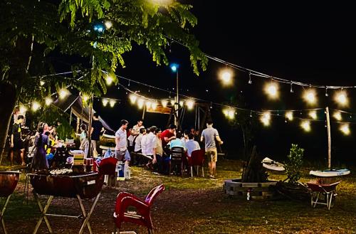 The Secret Garden Camping - Hồ Trị An的一群人坐在灯光下参加派对