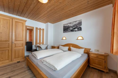 图克斯Fernerblick Apartments的一间卧室设有一张床和木制天花板