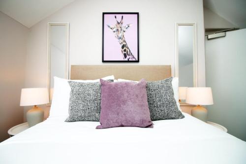 卡迪夫Stay with Free Parking at Archer Road Penarth的卧室配有一张壁挂长颈鹿图的床