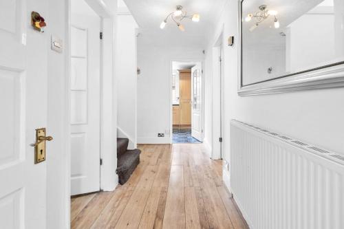 诺丁汉Bramcote Lane Spacious 5 BR House的走廊设有白色墙壁和硬木地板