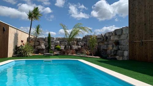 Adega D'Aldeia的一座游泳池,位于石墙旁的庭院内