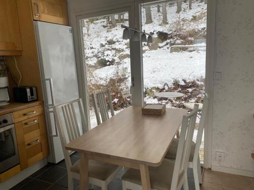 LindomeHouse with green garden, Göteborg, 6 beds的带窗户的厨房里的桌椅