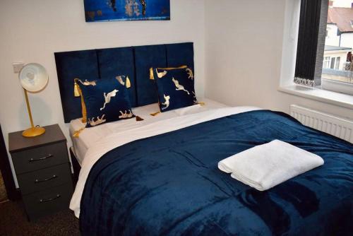 比斯顿Beeston House 3 BR and FREE Parking的一间卧室配有一张大床,提供蓝色的床单和枕头
