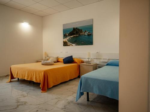 卡塔尼亚ROOMS alCentro的一间卧室设有两张床,墙上挂着一幅画