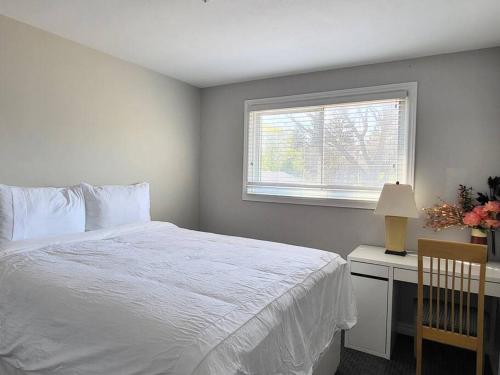 滨湖尼亚加拉Cozy Home in Niagara-on-the-Lake的卧室配有白色的床和窗户。