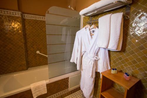 非斯Riad Raouia HAMMAM & SPA的浴室设有挂在浴缸旁架子上的毛巾