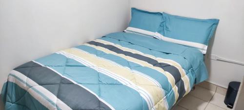 豪哈C&B APARTAMENTOS的一张带蓝色棉被和枕头的床