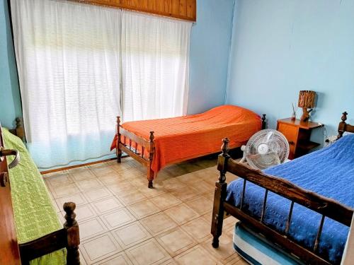 波特雷罗德洛斯弗内斯La Casa de Las Flores Potrero de los Funes的一间卧室设有两张床和窗户。