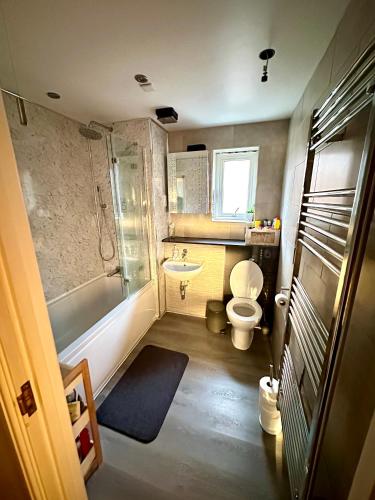 Escape Homestay的浴室配有卫生间、浴缸和水槽。