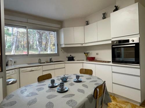 比埃什河畔阿斯普尔Villa Caprice à l'orée des bois的厨房配有桌椅和微波炉。