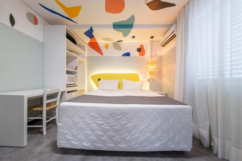弗洛里亚诺波利斯Bossa Jurerê Hotel的一间卧室配有一张白色床和黄色床头板