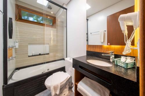 弗洛里亚诺波利斯Bossa Jurerê Hotel的一间带水槽、浴缸和卫生间的浴室