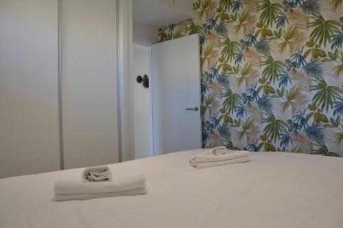 阿尔比尔Albir Beach & Sea Apt的卧室配有白色床和毛巾