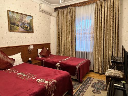 塔什干Sarbon Hotel Tashkent的酒店客房设有两张床和窗户。
