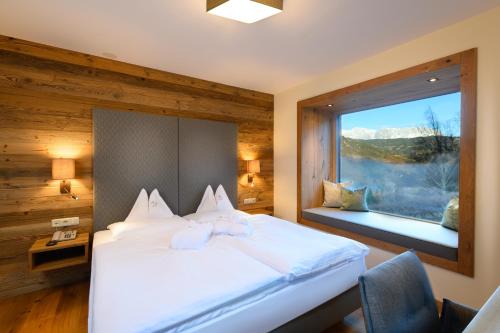 蓬高圣约翰Gut Berg Naturhotel的一间卧室设有一张大床和一个窗户。