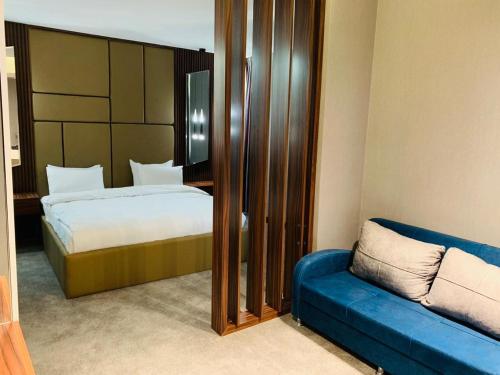 巴格达The Capital Heart Hotel的一间卧室配有一张床和一张蓝色的沙发