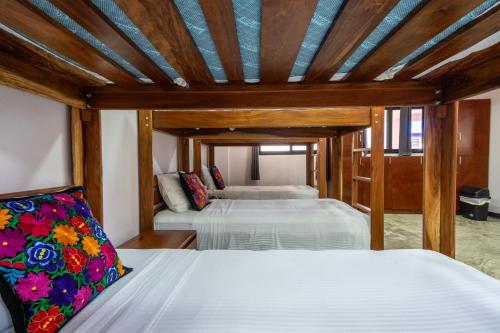 艾库玛尔Itza Hotel Akumal - Dive House的配有木天花板的客房设有两张床。