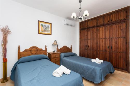 托罗克斯Villa Benizan的卧室内的两张床,配有蓝色的床单和毛巾