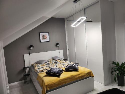 兰卡特Apartament Wiktoria的一间卧室配有一张带黄色床单和枕头的床。