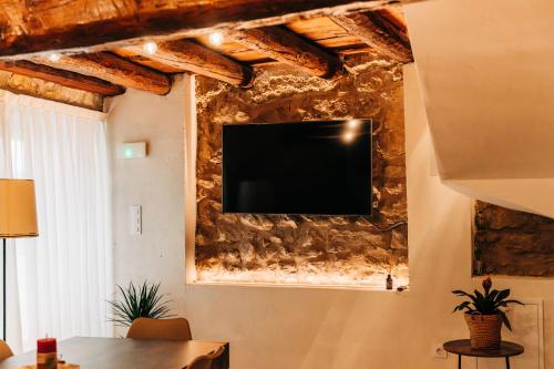 莫雷拉Casa Pelegrí的客厅的石墙上配有电视