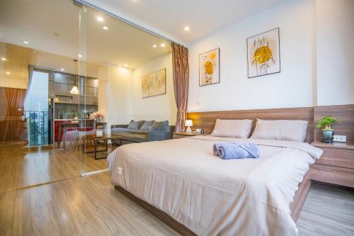 河内La Passion - Tay Ho Hanoi One Bedroom Apartment!的一间带大床的卧室和一间客厅