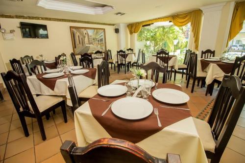 巴兰基亚Hotel Caribe Plaza Barranquilla的餐厅内带桌椅的用餐室