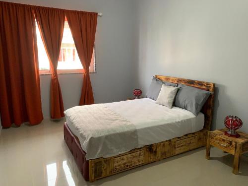 塔拉法尔J Martins Apart Hotel的一间卧室配有一张木床和窗户