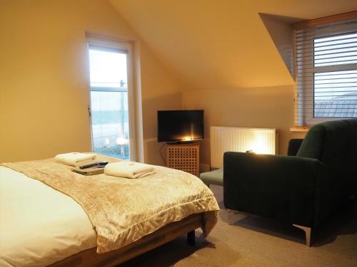 Bellochantuy阿盖尔酒店的一间卧室配有一张床、一把椅子和电视