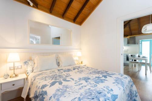 Las Crucescasa mo Tenerife的一间带蓝色和白色床的卧室以及一间用餐室