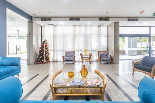 累西腓Flat Metropoles Ilha do Leite by Easy Home的客厅配有蓝色家具和圣诞树