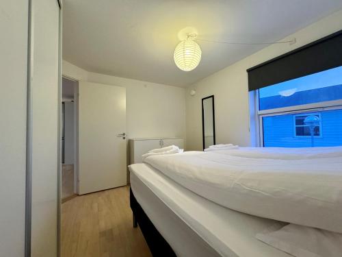 伊卢利萨特Hotel Nuka的白色的卧室设有一张大床和一个窗户