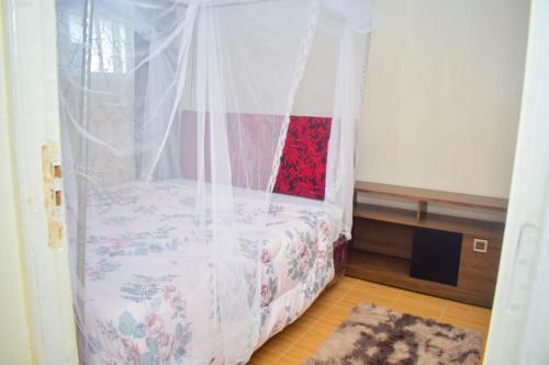 内罗毕Trinity Garden的一间卧室配有一张带天蓬的床