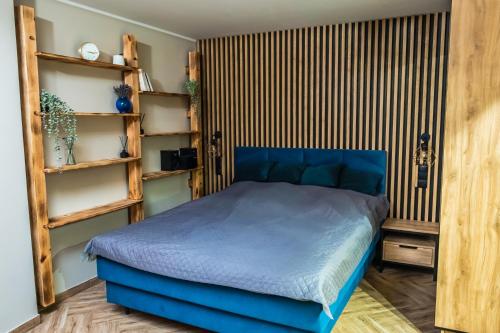 斯蒂格纳Pokoje Siódemka的一间卧室设有蓝色的床和木制架子