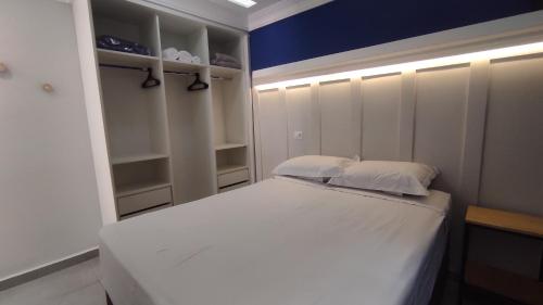 库里提巴Family House - Curitiba的卧室配有白色的床和蓝色的墙壁