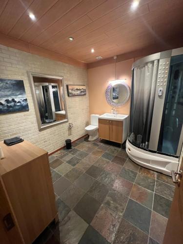 Stokkseyri艺术旅舍的浴室配有卫生间、盥洗盆和浴缸。