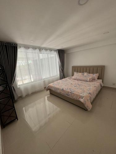 金边Superbe Maison Khmer的一间卧室设有一张床和一个大窗户