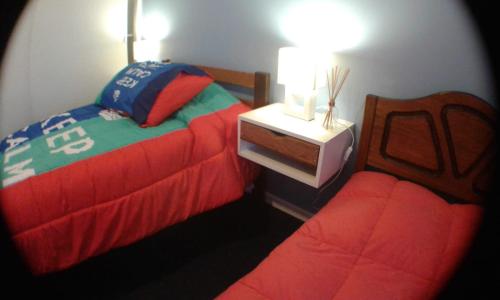 康塞普西翁Hostal San Valentín的一间卧室配有两张床,一个床头柜配有一张四柱床