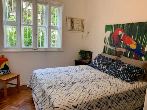 里约热内卢Apt Charmoso 3 Quartos Gavea的卧室配有一张床铺,墙上挂有鸟画