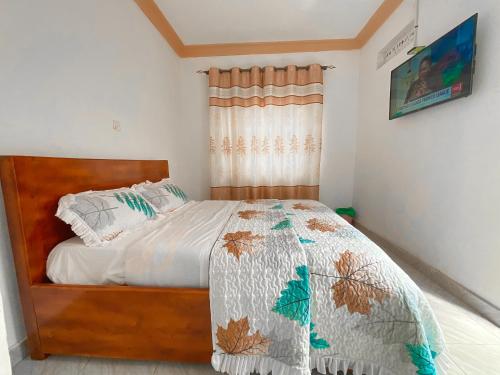 KisoroAgape House的一间卧室配有一张床和被子