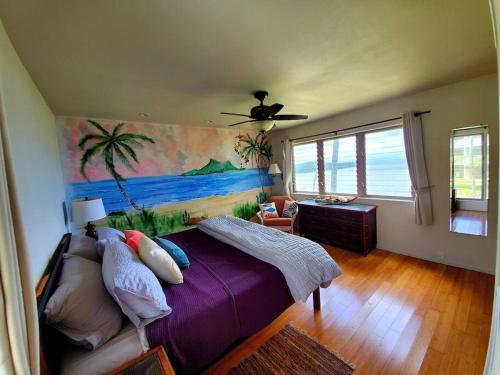 UalapueOceanfront true 2 bedroom w/lanai on Molokai的卧室配有一张床,墙上挂有绘画作品