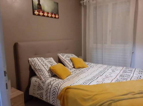 卢尔德Le jardin d'eden的一间卧室配有一张带两个黄色枕头的床