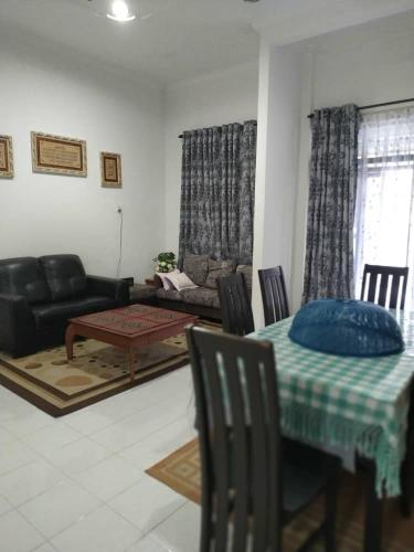 Homestay Seri Aman Pasir Puteh的客厅配有桌子和沙发