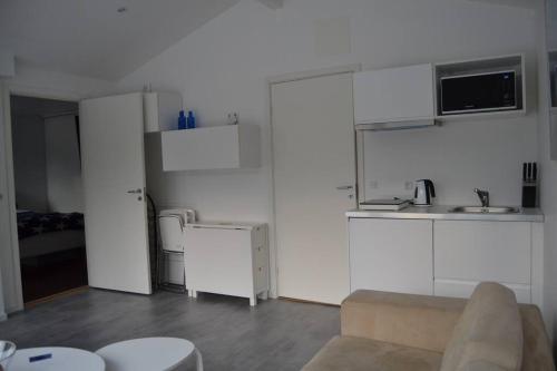 KlagshamnCalm villa-apartement near the sea and nature的客厅配有白色橱柜和沙发。