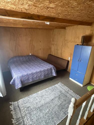 瓦尔迪维亚Reservas Cabañas Kramer的一间卧室配有一张床和一个蓝色的橱柜