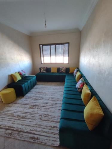 Ben YakhlefAppartement Cozy Louizia的客厅配有绿色沙发和黄色枕头